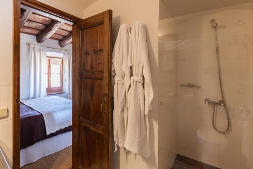 La salle de bains est pourvue d'une douche et d'une porte en verre. dans l'établissement El Palauet de Monells - Adults Only, à Monells
