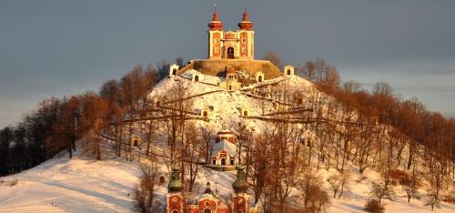 an old building on top of a mountain in the snow at Penzión Turista in Banská Štiavnica