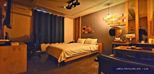 a bedroom with a bed and a desk and a chair at Manhatan Hotel 청주 in Cheongju