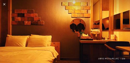 a bedroom with a bed and a desk with a mirror at Manhatan Hotel 청주 in Cheongju