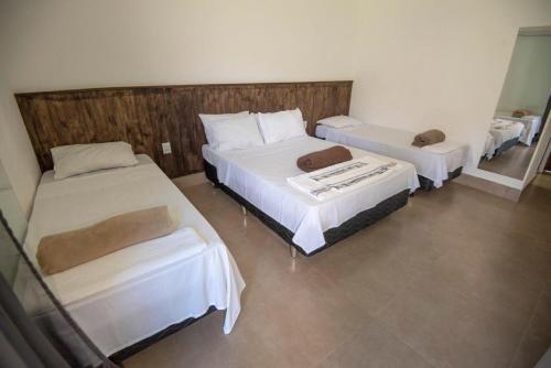 sypialnia z 2 łóżkami i lustrem w obiekcie Pousada Canyons w mieście Capitólio
