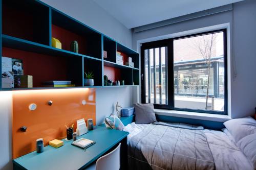 Highfield House Apartments في دبلن: غرفة نوم بسرير ومكتب ونافذة