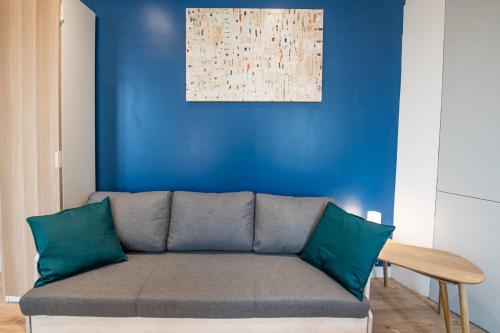 - un canapé dans le salon orné d'un mur bleu dans l'établissement Le Musigny - Superbe studio moderne au calme proche place Valmy, à Lyon