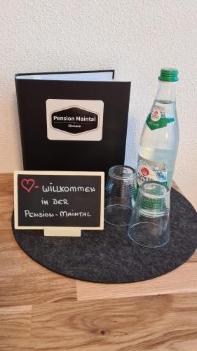 eine Flasche Wasser und eine Schachtel auf dem Tisch in der Unterkunft Pension Maintal Eltmann in Eltmann