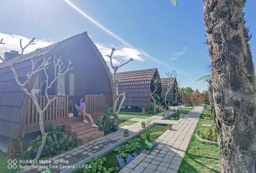 una persona seduta sul portico di una casa di Umah lumbung bedugul a Bedugul