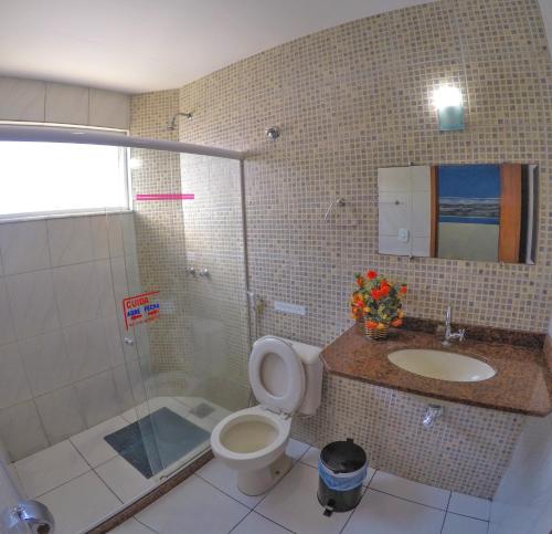 uma casa de banho com um chuveiro, um WC e um lavatório. em Pousada Águas do Forte em Cabo Frio