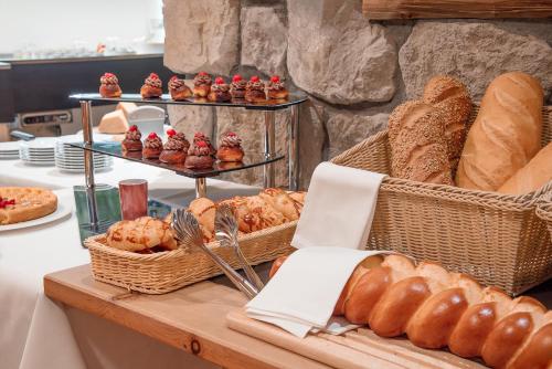 a bakery with bread and pastries on a table at Hotel San Gian in St. Moritz