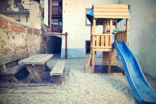 a wooden playground with a slide and a bench at Bed&Bike Prachatice in Prachatice