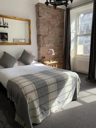 a bedroom with a large bed and a brick wall at Royal Mile Suites by the Castle in Edinburgh