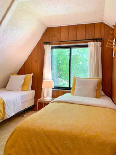 sypialnia z 2 łóżkami i oknem w obiekcie Le Rustique Orford Domaine Cheribourg w mieście Magog-Orford