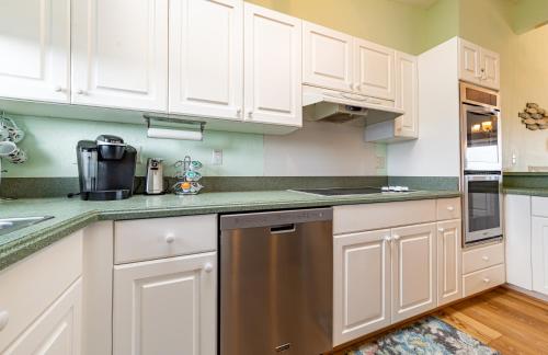 a kitchen with white cabinets and a stainless steel dishwasher at Duck R Way in Duck