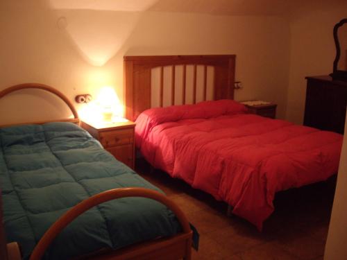 una camera da letto con due letti e un tavolo con una lampada di Cuevas Rio Baza a Baza