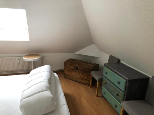 een slaapkamer met een wit bed en een houten dressoir bij Chez Jules ,Parking gratuit, 3ème Etage in Saint-Valery-sur-Somme
