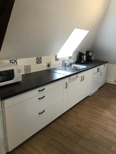 une cuisine avec un évier et un micro-ondes dans l'établissement Chez Jules ,Parking gratuit, 3ème Etage, à Saint-Valery-sur-Somme