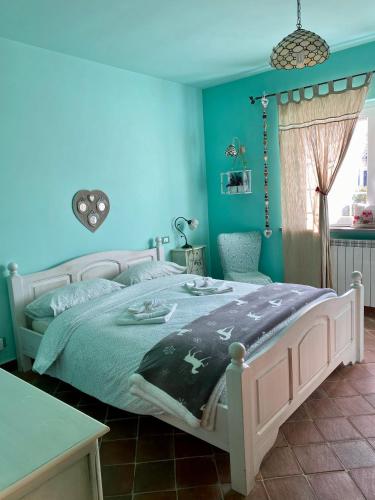 a bedroom with a bed with blue walls at Da Artù in Cittaducale