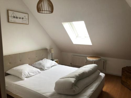 una camera da letto con un grande letto bianco e un lucernario di Chez Jules ,Parking gratuit, 3ème Etage a Saint-Valéry-sur-Somme