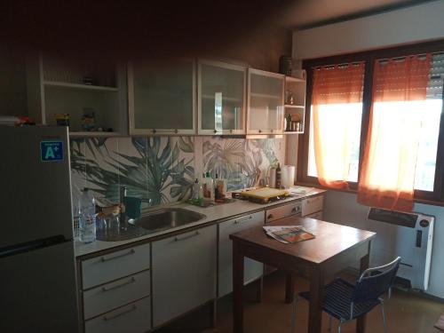 a kitchen with a table and a sink and a refrigerator at Fronte mare in Marotta