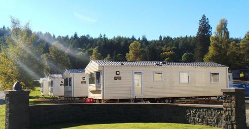 a tiny house is parked next to a train at Moffat Manor Holiday Park in Beattock