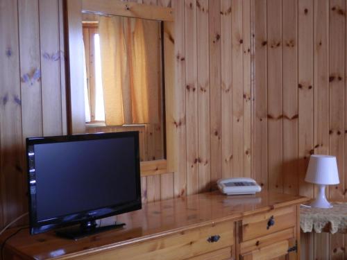 a television on a dresser with a lamp and a phone at Hotel Villa Stella in Cascia