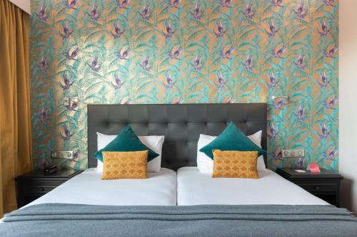 um quarto com uma cama com papel de parede floral em Hôtel Charlemagne by Happyculture em Lyon
