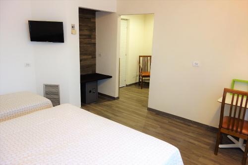 a room with two beds and a television on a wall at Euromotel Croce Bianca in Verona