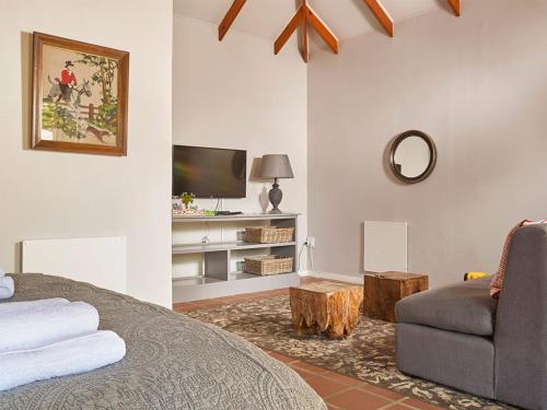 a bedroom with a bed and a couch and a tv at Highland Quarters in Clarens