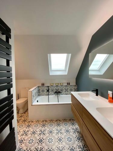 a bathroom with a tub and a toilet and a sink at Vakantiehuis Cas.tard in Zillebeke