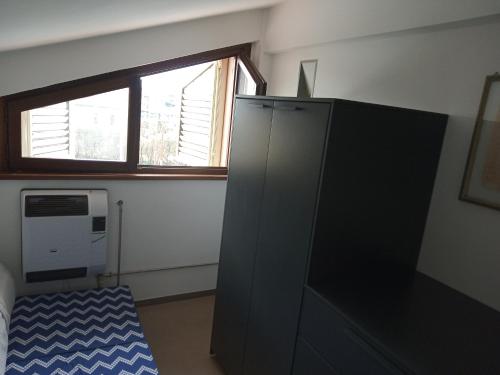a room with a black cabinet and a window at Fronte mare in Marotta