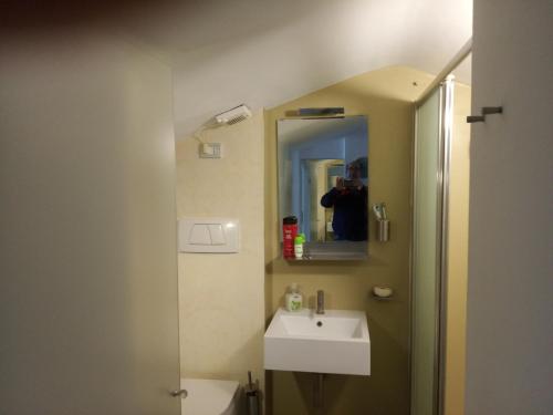 a person taking a picture of a bathroom with a sink at Fronte mare in Marotta