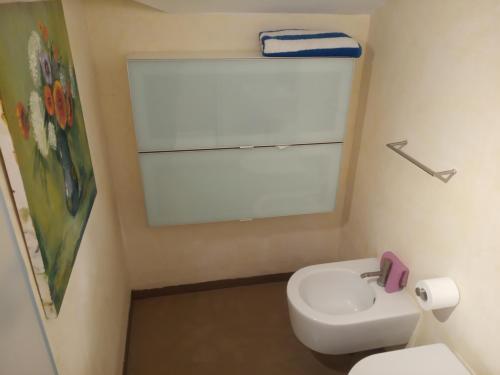 a bathroom with a white toilet and a sink at Fronte mare in Marotta