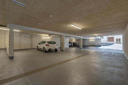a parking garage with a white car parked in it at Anthony's Peaks & Pillows in Sankt Anton am Arlberg