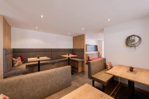 a restaurant with benches and tables and booths at Anthony's Peaks & Pillows in Sankt Anton am Arlberg