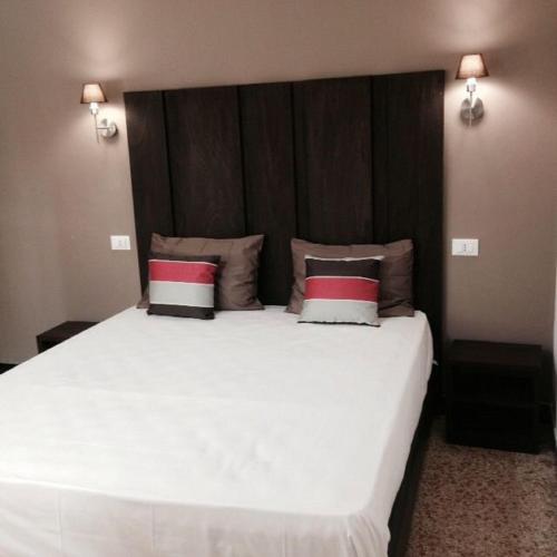 a bedroom with a large white bed with two pillows at Hotel Bologna in Genova