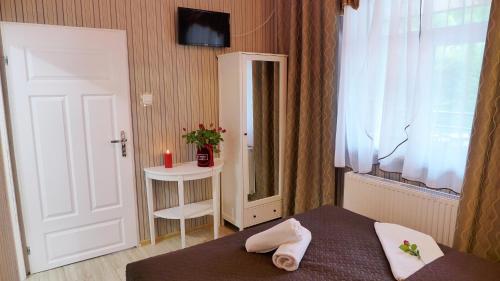 a bedroom with a bed and a window and a table at Wrzos & Belvedere in Kudowa-Zdrój