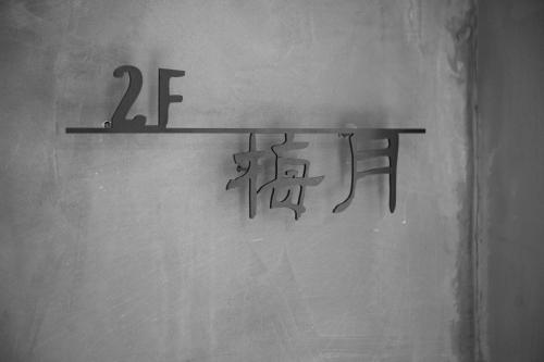 a shelf with writing on the wall in a room at Ren House大仁哥文旅 in Taitung City