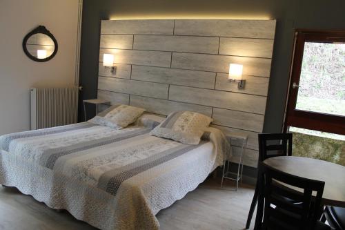Een bed of bedden in een kamer bij Hôtel Restaurant Aux Genêts d'Or