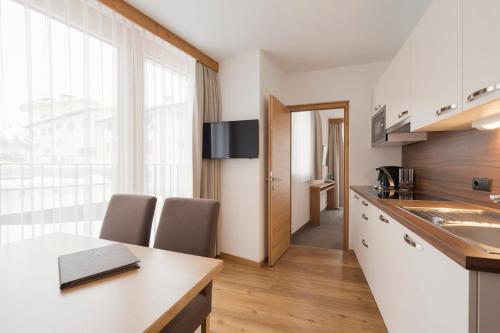 a kitchen with a table and two chairs in a room at Anthony's Peaks & Pillows in Sankt Anton am Arlberg