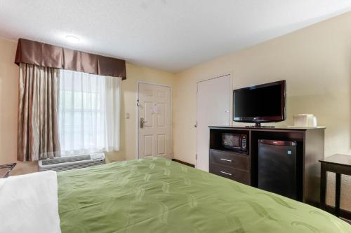 a hotel room with a bed and a flat screen tv at Quality Inn & Suites Lexington in Lexington