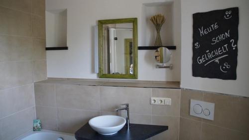 een badkamer met een wastafel en een spiegel bij Ferienhaus Mutter Anna's Refugium in Stolpen