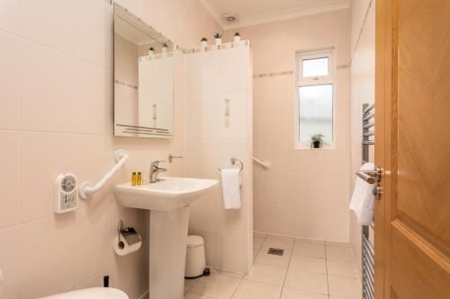 a bathroom with a sink and a toilet and a mirror at Sunset View - Donnini Apartments in Ayr