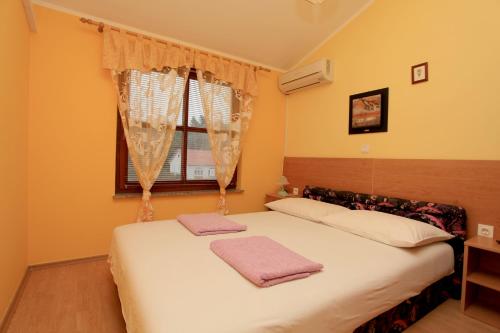 1 dormitorio con 2 camas y toallas rosas. en Apartments Vila Afrodita, en Vir