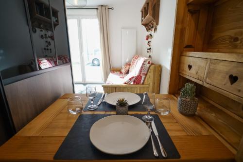 uma mesa de jantar com um prato branco em Le Petit Chalet - Cosy studio in Lathuile for 2 people em Lathuile