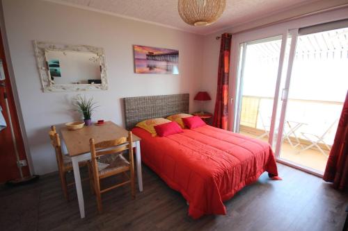 - une chambre avec un lit et une table avec une couverture rouge dans l'établissement Studio climatise 2 couchages, Wifi, VUE MER directement à PORTIRAGNES PLAGE LXBFM10, à Portiragnes