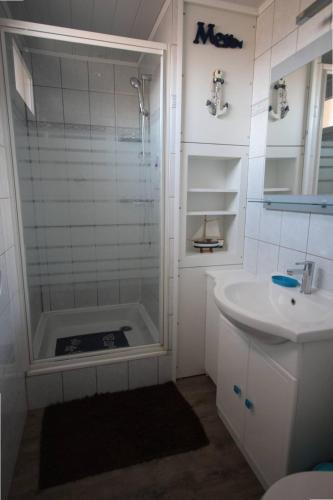 une salle de bain blanche avec une douche et un lavabo dans l'établissement Studio climatise 2 couchages, Wifi, VUE MER directement à PORTIRAGNES PLAGE LXBFM10, à Portiragnes