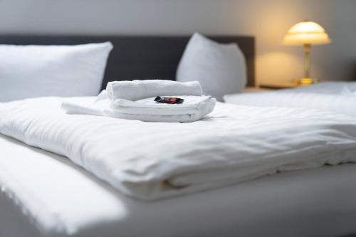 a bed with white sheets and a towel on it at Gasthof 'Zum Reifberg' in Ilmenau