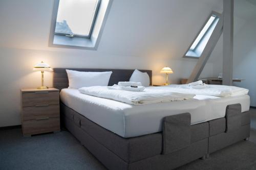 a bedroom with a large white bed with skylights at Gasthof 'Zum Reifberg' in Ilmenau