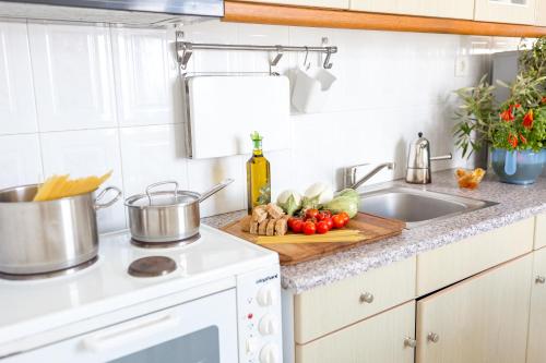 a kitchen counter with a cutting board with vegetables on it at Acrothea Suites and Villas - Akrotiri Caldera - Santorini in Akrotiri