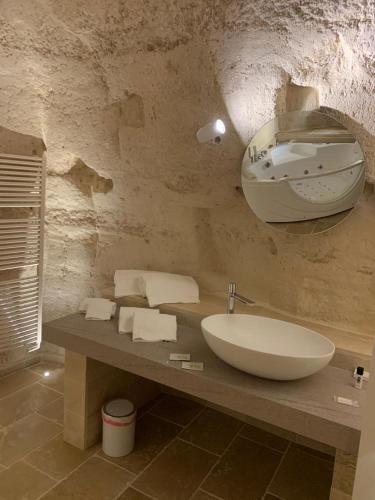 a bathroom with a sink and a mirror on a counter at 5 Elementi Sassi Matera in Matera