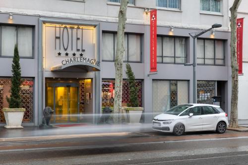 a white car parked in front of a store at Hôtel Charlemagne by Happyculture in Lyon