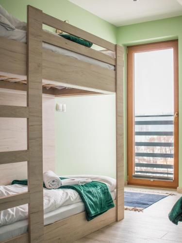 a bedroom with bunk beds and a door with a window at OSADA Rokicie in Kluszkowce